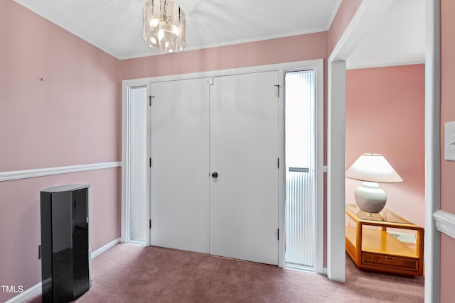 interior space with a closet, a notable chandelier, crown molding, and carpet floors