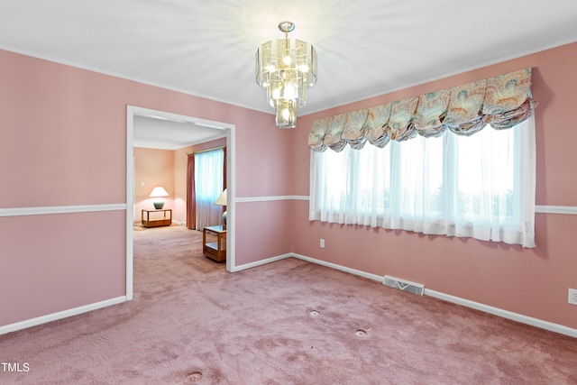 unfurnished dining area featuring visible vents, baseboards, ornamental molding, carpet floors, and an inviting chandelier