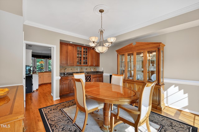 2514 Mcgowan Ct, Wake Forest, NC 27587 - dining room featuring light wood-style floors, ornamental molding, a chandelier, and wet bar