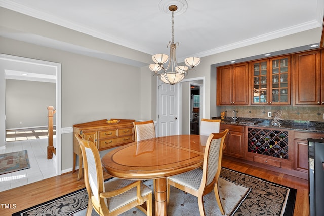 2514 Mcgowan Ct, Wake Forest, NC 27587 - dining space with ornamental molding, light wood-style flooring, a chandelier, and bar area