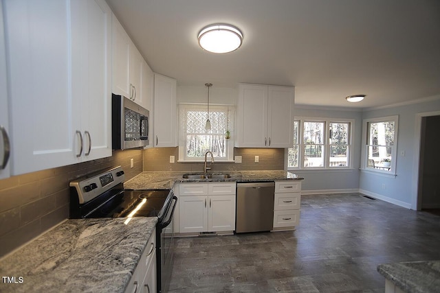 kitchen with stone countertops, a sink, decorative backsplash, white cabinets, and appliances with stainless steel finishes