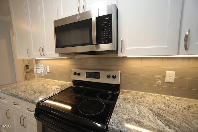 kitchen with light stone counters, stainless steel appliances, tasteful backsplash, and white cabinets