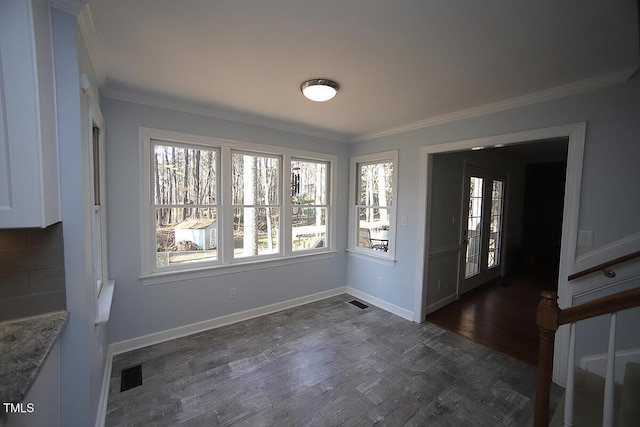 unfurnished dining area featuring visible vents, a healthy amount of sunlight, dark wood-style floors, and crown molding