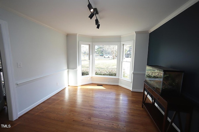 living room featuring baseboards, wood finished floors, and crown molding