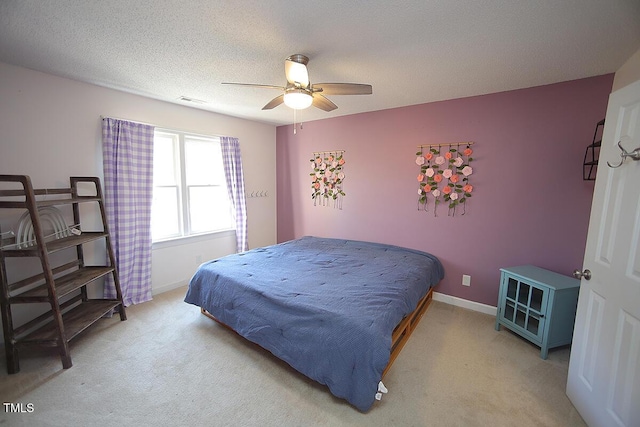 bedroom with visible vents, baseboards, light colored carpet, and a textured ceiling