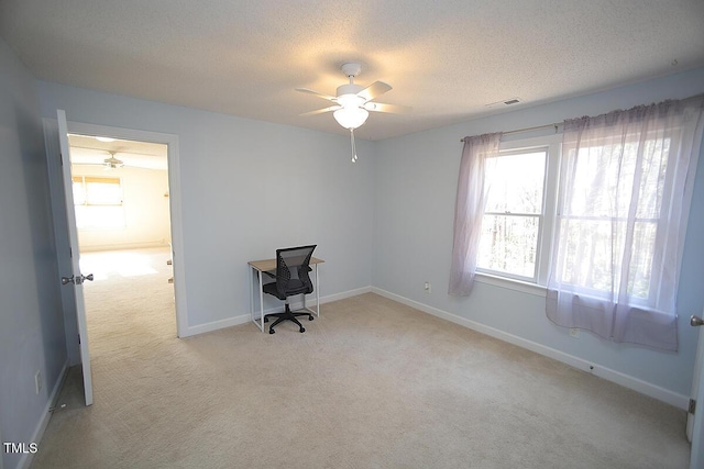 interior space featuring visible vents, a textured ceiling, baseboards, and a ceiling fan