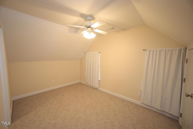 bonus room featuring baseboards, visible vents, ceiling fan, vaulted ceiling, and light colored carpet