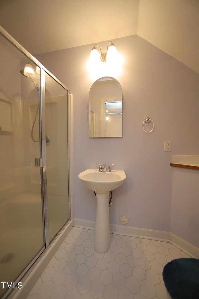 bathroom with tile patterned floors, a shower stall, baseboards, and lofted ceiling