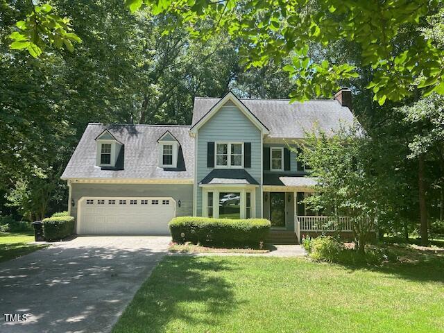 1501 Ramson Ct, Raleigh, NC 27603 - view of front facade with driveway, a front yard, an attached garage, a chimney, and covered porch