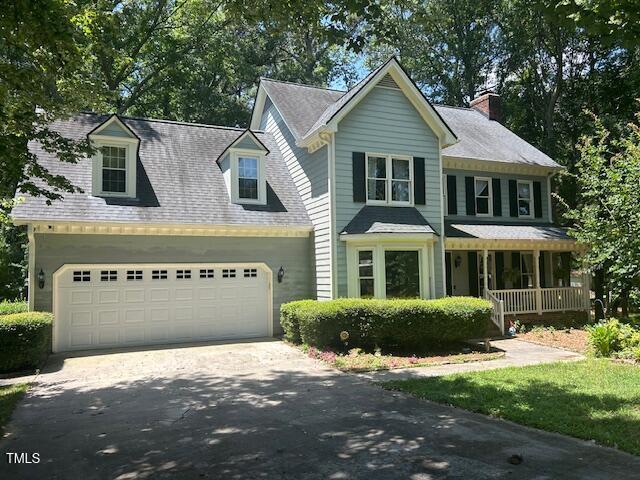 1501 Ramson Ct, Raleigh, NC 27603 - view of front of house with a porch, driveway, a chimney, and an attached garage