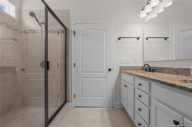 bathroom with a shower stall, double vanity, and a sink