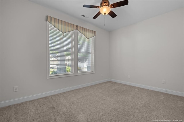 carpeted empty room featuring a ceiling fan, baseboards, and visible vents