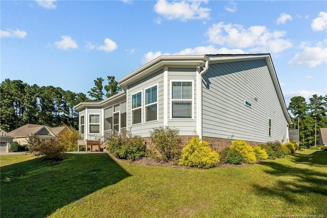 view of home's exterior with a yard and a sunroom