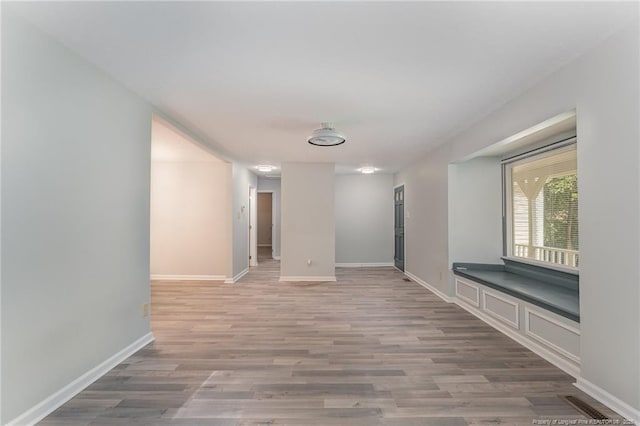 unfurnished room featuring visible vents, baseboards, and wood finished floors