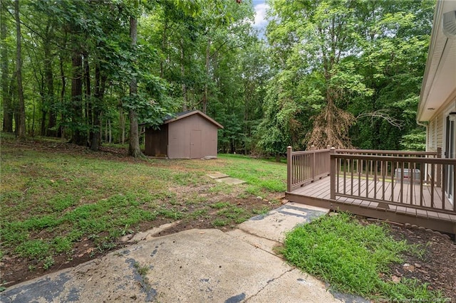 view of yard with an outbuilding, a shed, and a wooden deck