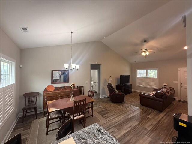 dining room with dark wood finished floors, visible vents, baseboards, and vaulted ceiling