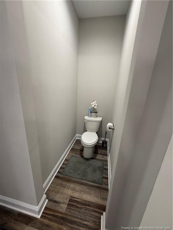 bathroom featuring toilet, wood finished floors, and baseboards