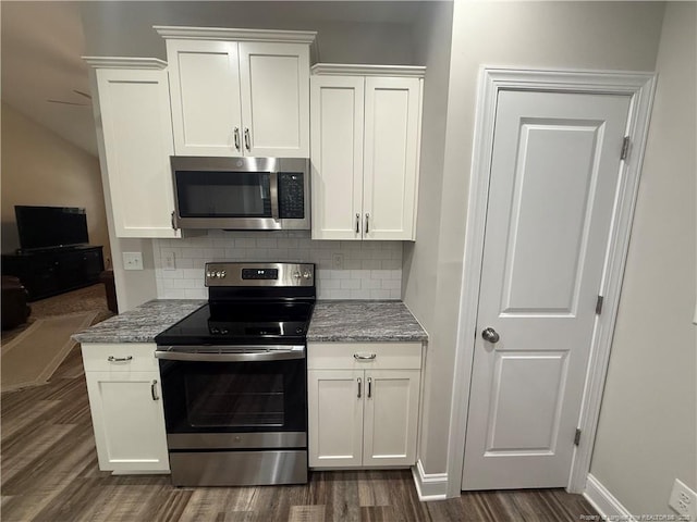 kitchen featuring tasteful backsplash, appliances with stainless steel finishes, white cabinetry, and dark wood-type flooring