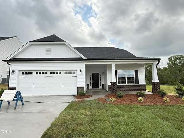 1794 Parham Dr, Graham, NC 27253 - view of front of home featuring brick siding, an attached garage, a front lawn, driveway, and a porch