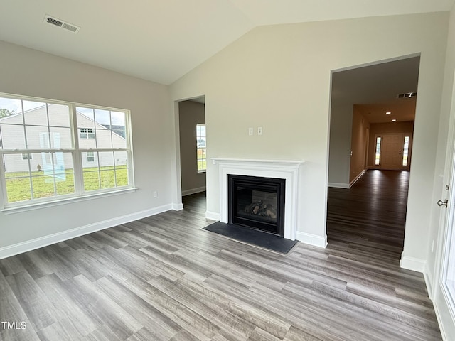 1794 Parham Dr, Graham, NC 27253 - unfurnished living room with wood finished floors, a fireplace with flush hearth, baseboards, and high vaulted ceiling