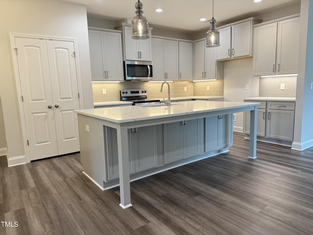 1794 Parham Dr, Graham, NC 27253 - kitchen featuring appliances with stainless steel finishes, a sink, dark wood-type flooring, recessed lighting, and an island with sink