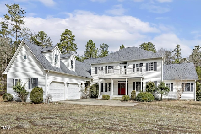 colonial inspired home featuring a porch, roof with shingles, concrete driveway, an attached garage, and a balcony