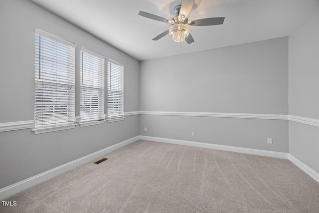 unfurnished room featuring visible vents, baseboards, ceiling fan, and carpet flooring