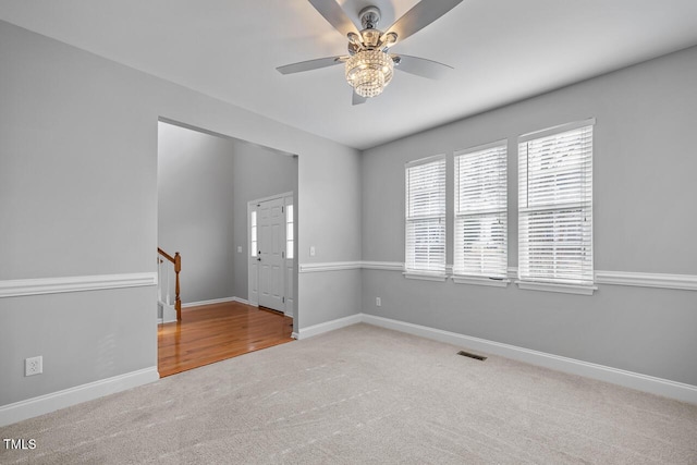 empty room with visible vents, carpet, and baseboards