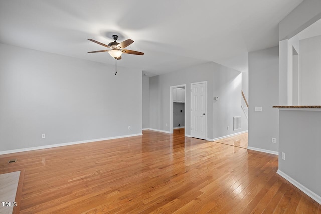 unfurnished living room with visible vents, light wood-style flooring, baseboards, and ceiling fan