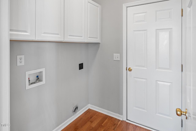 laundry room featuring electric dryer hookup, washer hookup, dark wood-style floors, cabinet space, and baseboards