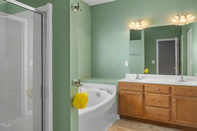 bathroom featuring tile patterned flooring, double vanity, a garden tub, and a sink