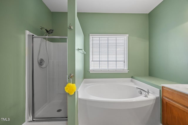 full bathroom featuring vanity, a garden tub, and a stall shower