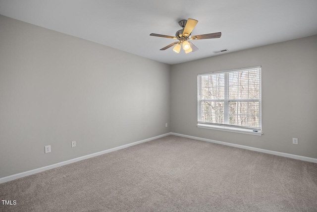 empty room with ceiling fan, carpet, visible vents, and baseboards