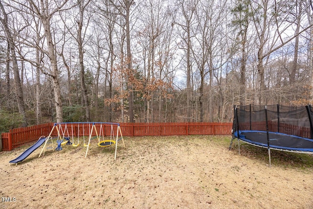 view of jungle gym featuring a trampoline and a fenced backyard