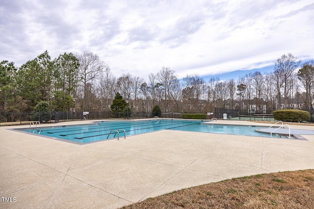 pool with a patio and fence