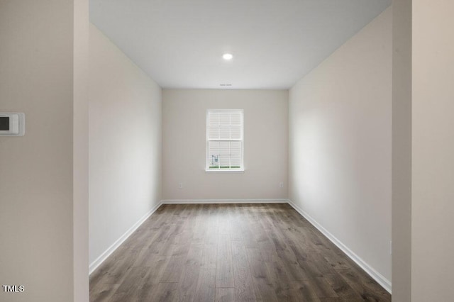 unfurnished room with visible vents, wood finished floors, and baseboards