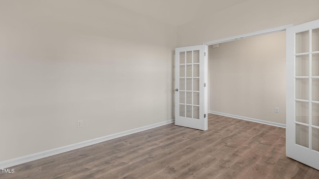 unfurnished room featuring french doors, baseboards, and wood finished floors