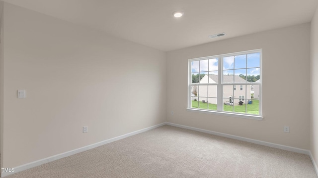 empty room featuring visible vents, carpet floors, and baseboards