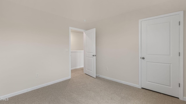 unfurnished bedroom with baseboards and light colored carpet