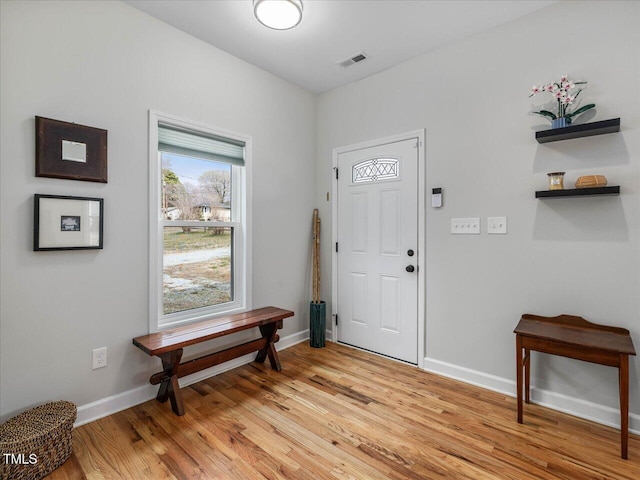 foyer entrance featuring visible vents, baseboards, and light wood-style floors