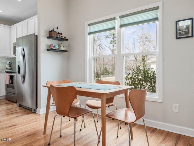 dining area featuring a wealth of natural light, baseboards, and light wood-style floors