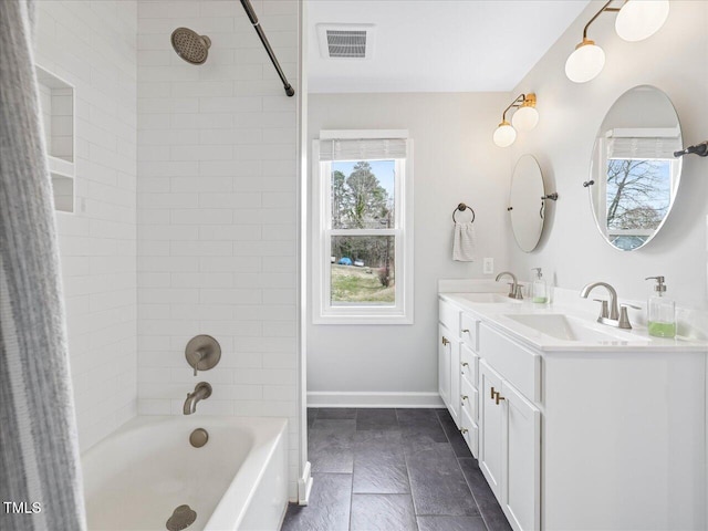 bathroom featuring a sink, visible vents, baseboards, and tub / shower combination