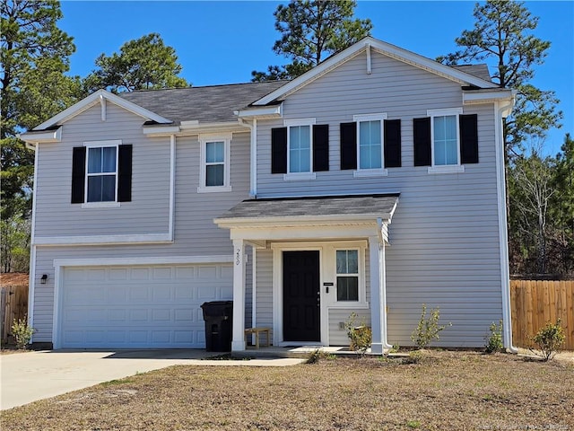 traditional home featuring concrete driveway, an attached garage, and fence