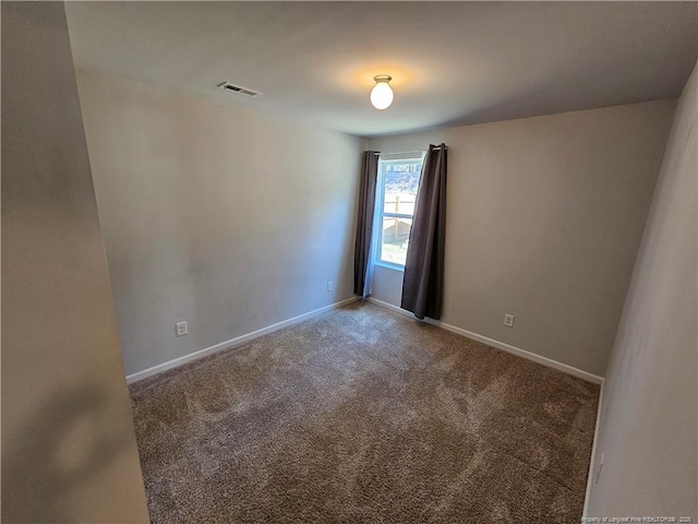 carpeted spare room with visible vents and baseboards