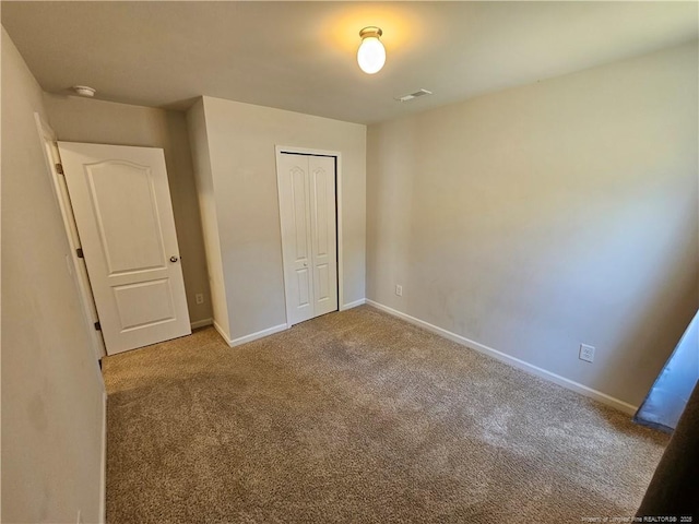 unfurnished bedroom with visible vents, carpet flooring, baseboards, and a closet