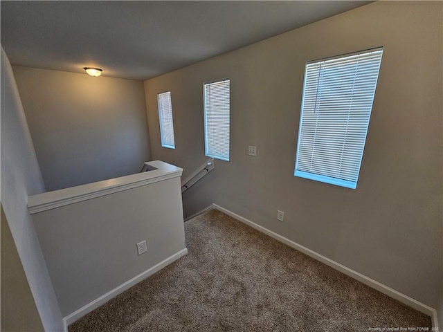 carpeted spare room with baseboards