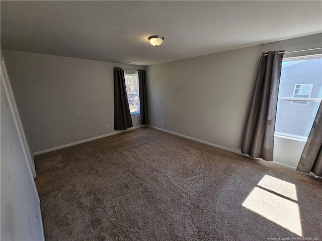 spare room with baseboards and carpet