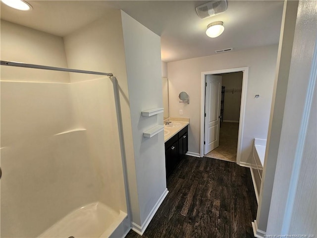 full bath with vanity, wood finished floors, visible vents, baseboards, and a shower stall