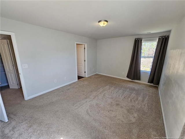 unfurnished room featuring baseboards and carpet floors