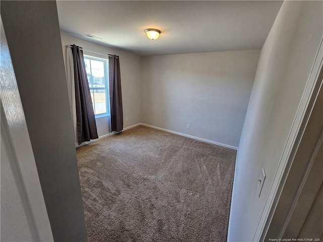 carpeted empty room featuring baseboards